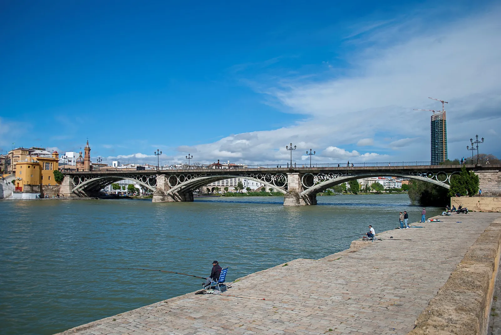 The Isabel II bridge and the Triana bank seen from the river wall on a bright day