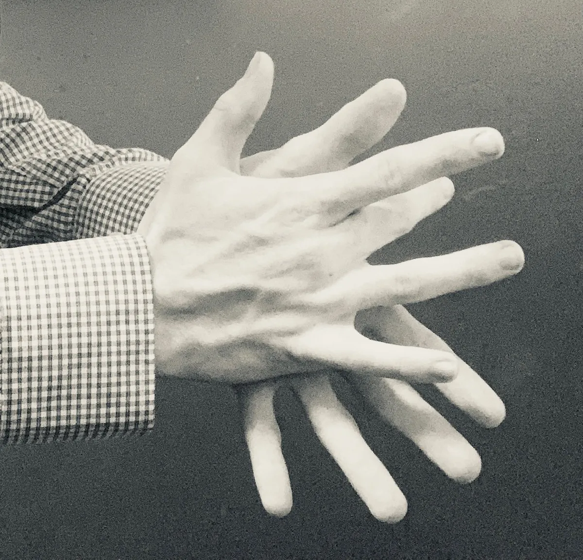 Two hands mid-clap in a black and white photograph